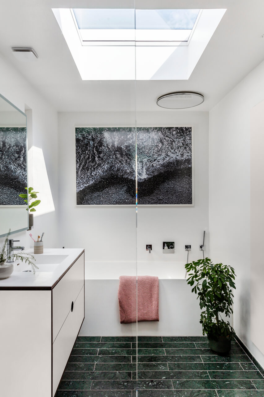 Bathroom with a big roof window where sun fills the room with light.