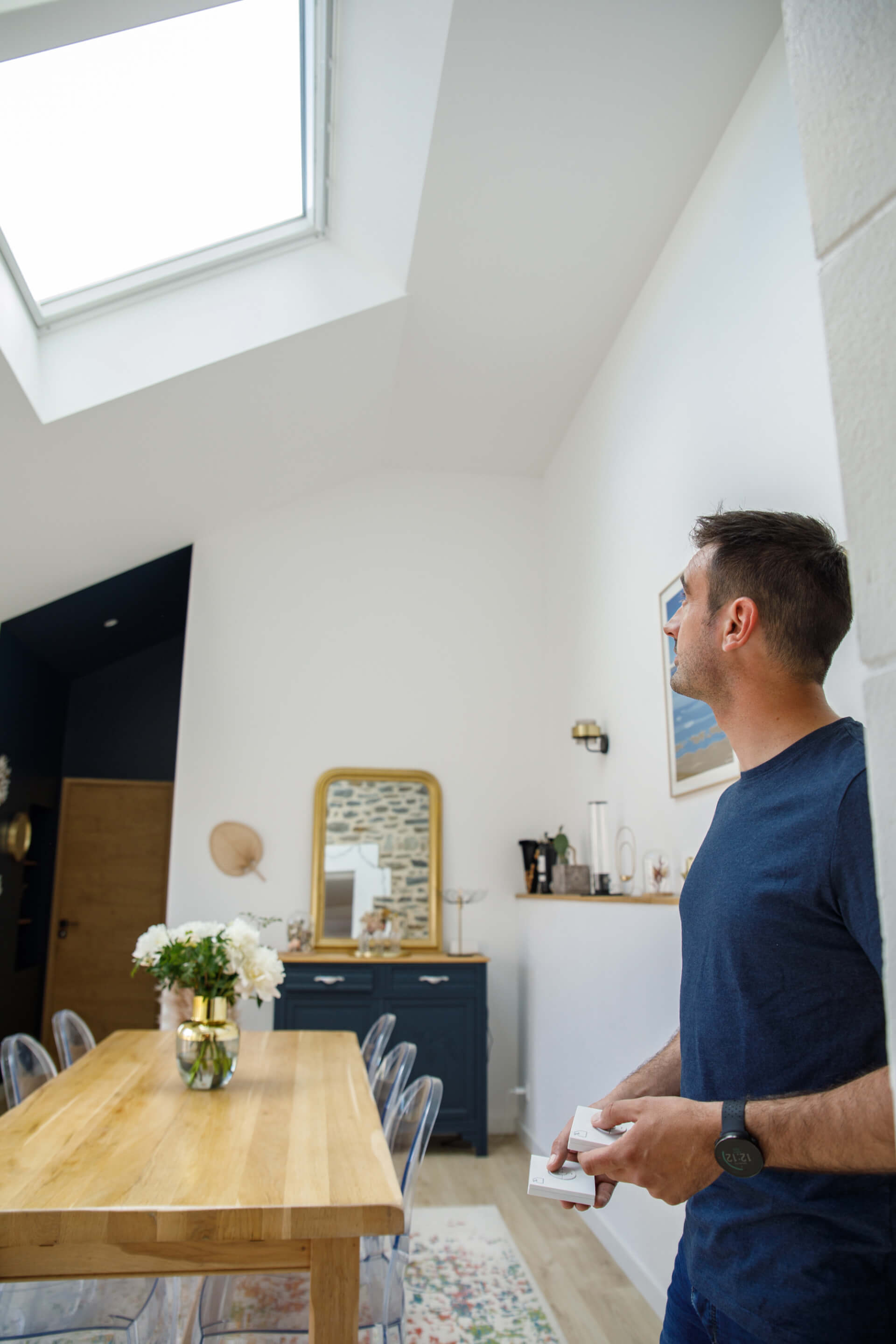 Man standing in the dining area and looking up to the roof windows