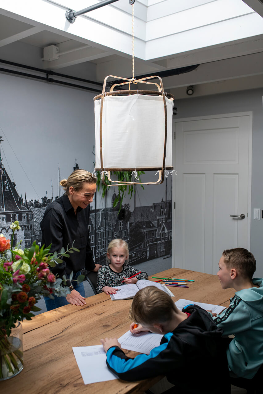 Woman and three kids in the dining room.