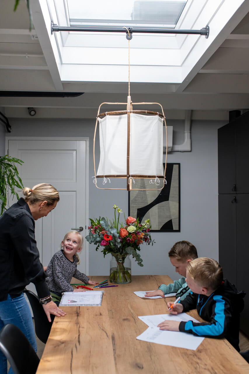 Woman and three kids in the dining room.