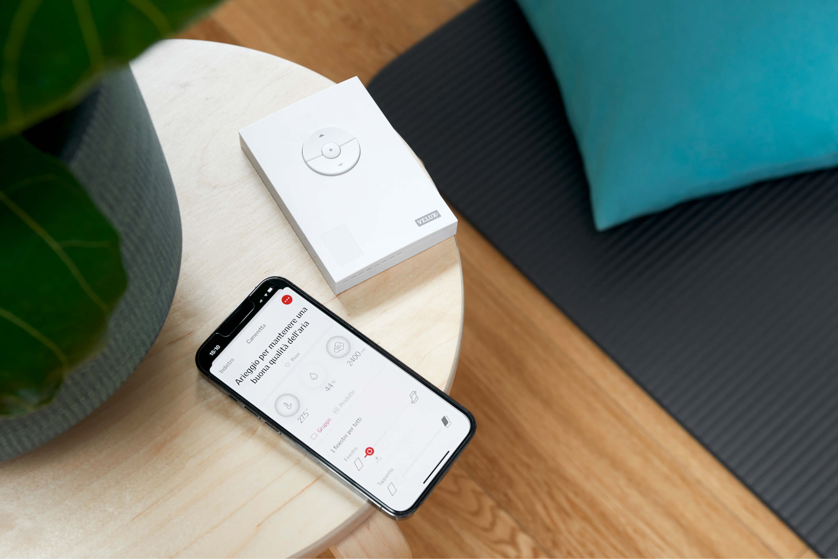 Un téléphone avec application VELUX et une télécommande pour VELUX ACTIVE sur la table